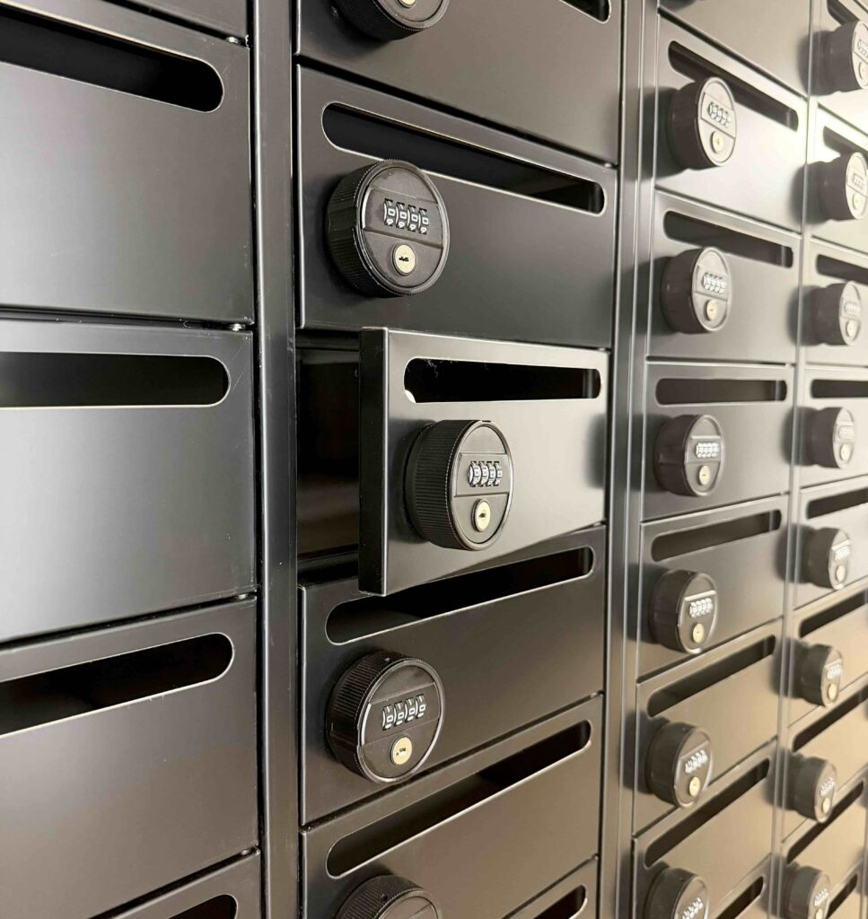 Geöffnetes Fach einer modernen schwarzen Briefkastenanlage mit Zahlenschloss im Smarvo-Gebäude.