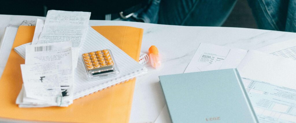 Ein Schreibtisch mit Taschenrechner, Notizblöcken und sortierten Belegen als Symbol für die Gewerbesteuerberechnung.